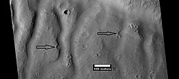 Group of channels on a mound, as seen by HiRISE under HiWish program. Arrows show eroded craters.