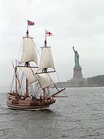 A replica of the early 17th century Godspeed flying the flags of Great Britain and the Kingdom of England
