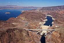 Aerial view of Hoover Dam with Lake Mead behind it and desert landscape