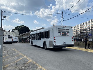 Two white buses in a busway at a disused light rail station