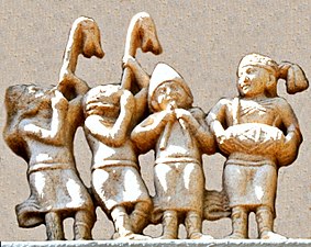 Detail of the foreigners, in Greek dress and playing carnyxes and aolus flute. Northern Gateway of Stupa I (detail).