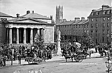 Market held in front of Dundalk Courthouse with Maid of Erin statue to front and bell tower of St Patrick's Church visible in background, c. 1906
