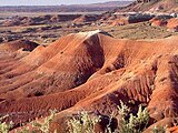 A landscape of the red rocks and lavender shades of the mountains in the Painted Desert.