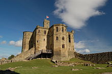 A tall tower stands above the ruined castle. A wooden staircase leads into the tower, its windows are empty. The facing is smooth ashlar, and on top is a smaller square look-out tower on which stands a flagpole.