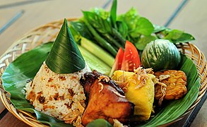 Nasi tutug oncom, roasted oncom mashed with steamed rice, served with side dishes.