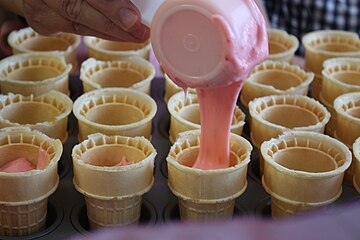 Cake batter is poured into an ice cream cone prior to baking