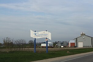 Welcome sign on WIS 54, farm in the background