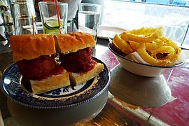 A meatball sandwich with onion rings at a London restaurant