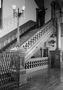 Black-and-white image of the main staircase in the Park Avenue Armory. The staircase is built of iron and clad with oak.