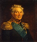 Painting shows a gray-haired man with a round face wearing a very dark military coat with gold epaulettes, a gold collar and a blue velvet sash over his shoulder.