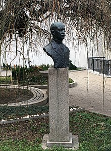 Bust of mustachioed man in a park