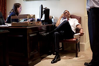 President Barack Obama listens to Senior Advisor David Axelrod in the outer Oval Office on June 26, 2009. At left is Personal Secretary Katie Johnson.