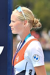 Ilse Kolkman schaut bei der Siegerehrung nach rechts. Sie trägt das niederländische Nationaltrikot über einem weißen T-Shirt. Um den Hals hängt ein blaues Band, an dem die nicht sichtbare Silbermedaille befestigt ist. Ihre Sonnenbrille hat sie hochgeschoben.