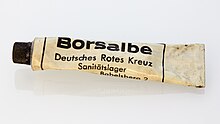 Eine beigefarbene, etwas schmutzig wirkende Metalltube mit der Aufschrift "Borsalbe Deutsches Rotes Kreuz Saninätslager Babelsberg 2"
