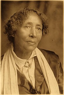 Head and upper body sepia photograph of Parsons with short curly hair, looking past camera
