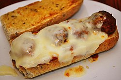 A meatball sandwich with melted cheese