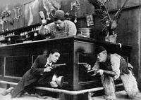 Keaton (left) with Roscoe Arbuckle (top) and Al St. John in a still from Out West (1918)