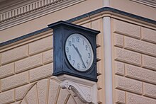 A clock stopped at 10:25 located outside of Bologna Centrale railway station.