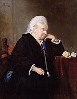 Black and white portrait of an elderly Queen Victoria, seated and looking right with a stoic expression, her arm resting on a table and her hand against her chin.