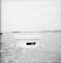 Der versenkte und vollkommen hochgefahrene Turm eines Pickett-Hamilton Retractable Fort auf einem Flugplatz in Südengland
