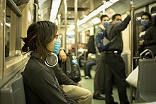 People on a subway wearing face masks.