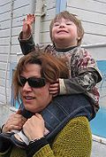 A child with Down syndrome piggy-backing on an adult