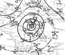 Weather map indicating barometric pressures over the southwestern Caribbean Sea using contours and wind barb symbols to indicate observations in select locations during the represented time. The hurricane is denoted at center with a capital L.