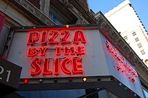A sign for pizza by the slice at a restaurant in San Francisco, California