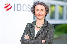 Prof. Dr. Anna Katharina in front of a column which says "IDOS". She is Director of the German Institute of Development and Sustainability (IDOS)