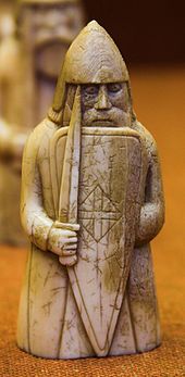 Photograph of an ivory gaming piece depicting an armed warrior