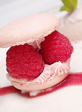 A macaron with raspberries