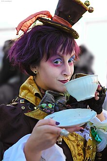 A photo of a Mad Hatter cosplayer posing with a tea cup.