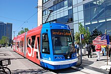 A blue and red-painted streetcar with "Made in USA" displayed on its side