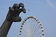 The statue's hand with the Capital Wheel on the background