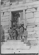 Black and white photograph showing men in military uniform, posing in the gateway.
