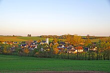 Image of a village surrounded by pastures flanked by rows of trees