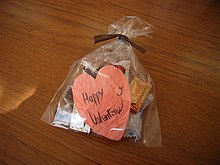 A small plastic bag with chocolates and a heart-shaped note reading "Happy Valentine".