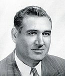A black-and-white image of the face of a white man in a suit