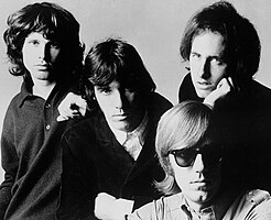 The Doors in 1966: Jim Morrison (left), John Densmore (center), Robby Krieger (right) and Ray Manzarek (seated)