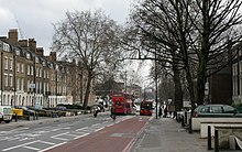City Road as seen from Angel. A tree-lined street in winter with buses travelling in either direction.
