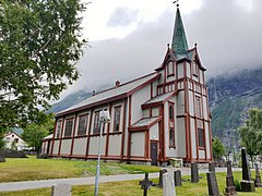 Foto einer Holzkirche in bergiger Umgebung