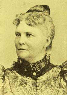 B&W portrait photo of a middle-aged women with her hair in an up-do.