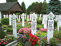 „Holzstickel“ als Grabsteinersatz auf einem südhessischen Friedhof