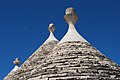 Carved stone pinnacles atop refurbished trullo cones (Alberobello)