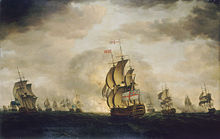 An oil painting depicting a sea battle. The sky has dark clouds with patches of blue, and the sea is grey. Warships are visible in the distance, some of which are exchanging cannon fire. A British warship occupies the centre foreground, obscuring an explosion behind it.