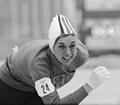A woman in skating garb, in a competition pose