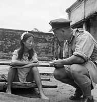 A young Burmese woman from one of the Imperial Japanese Army's "comfort battalions" is interviewed by a British Royal Air Force officer in Rangoon after being liberated in August 1945.