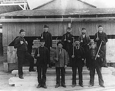 Workers holding measuring sticks at the Hawkesbury Mills, around 1895.