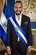 President of El Salvador Nayib Bukele wearing the presidential sash with the national flag standing behind