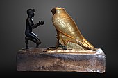 Taharqa offering wine jars to Falcon-god Hemen;[63] 690–664 BC; bronze, greywacke, gold and wood; length: 26 cm, height: 19.7 cm, width: 10.3 cm; Louvre